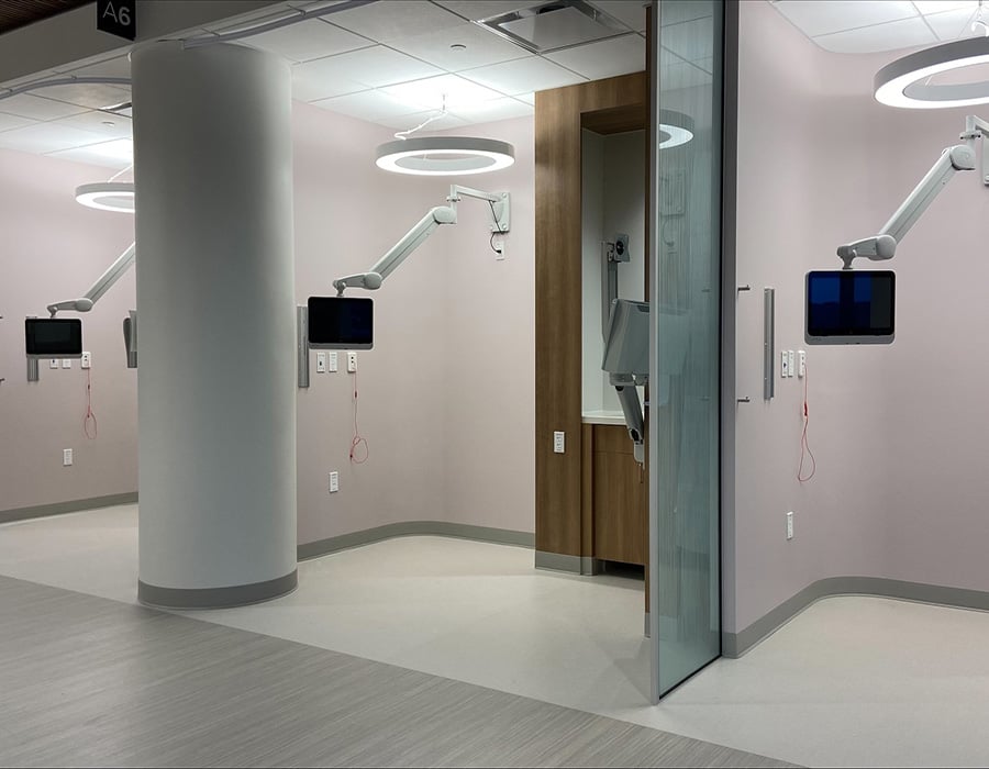 Three medTV16 patient televisions mounted on the wall using TV arms, each separated by partitions. This is an example of using multiple arm-mounted televisions in a shared patient space.