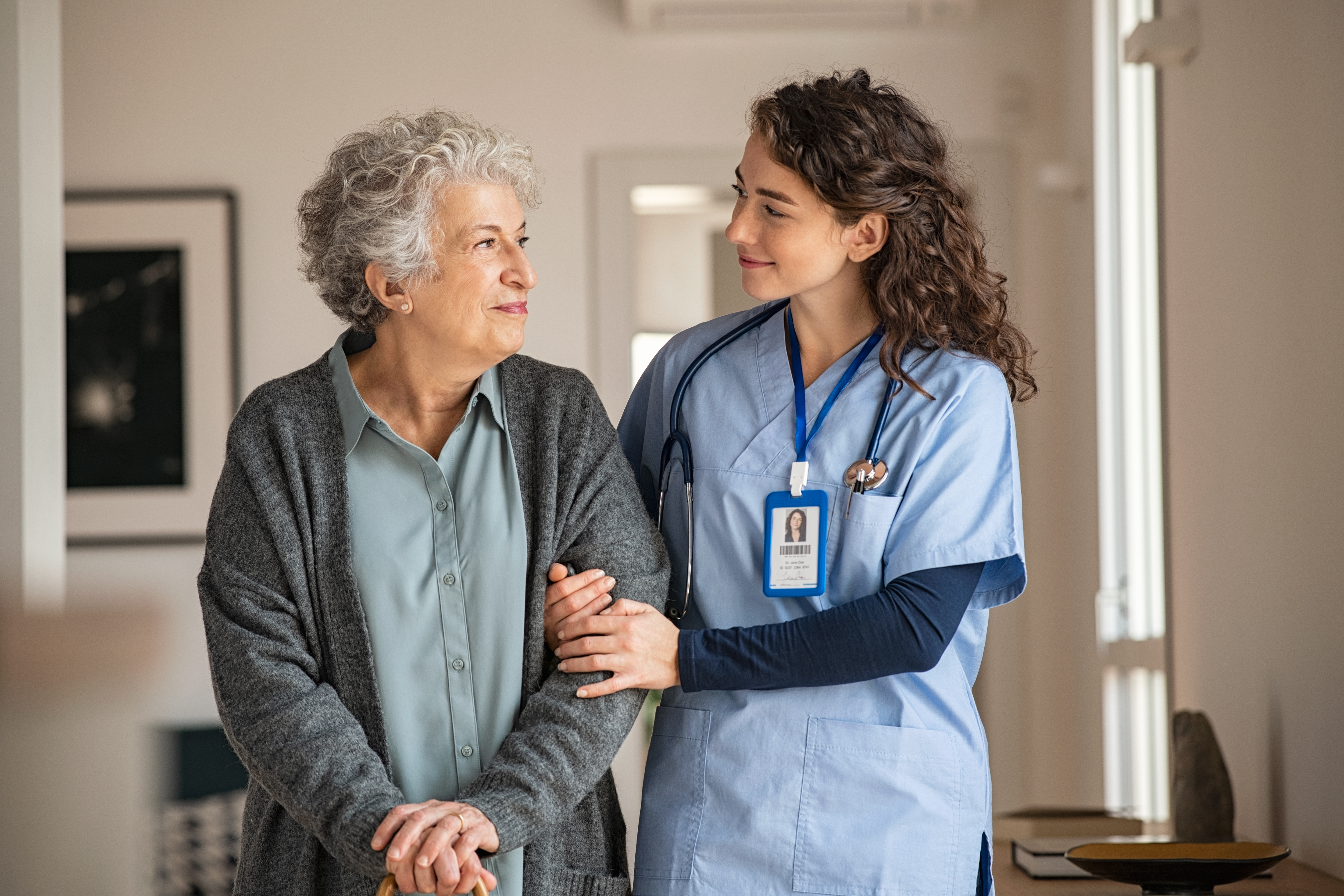 Nurse assisting elderly woman with walking