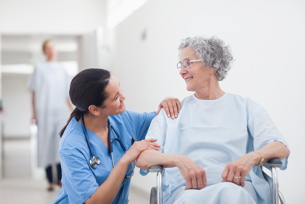 nurse with patient smiling in hallway