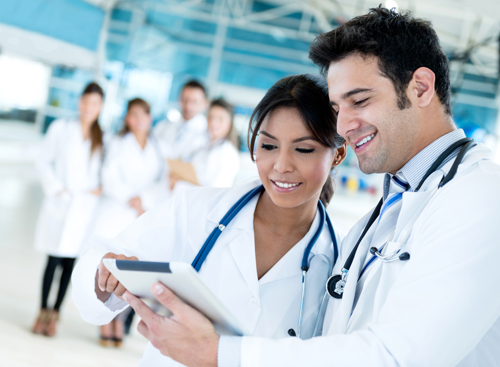 Couple of doctors talking and using a tablet computer